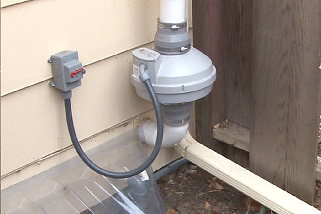 Exterior radon mitigation fan and vent pipe installed at a Lancaster County home